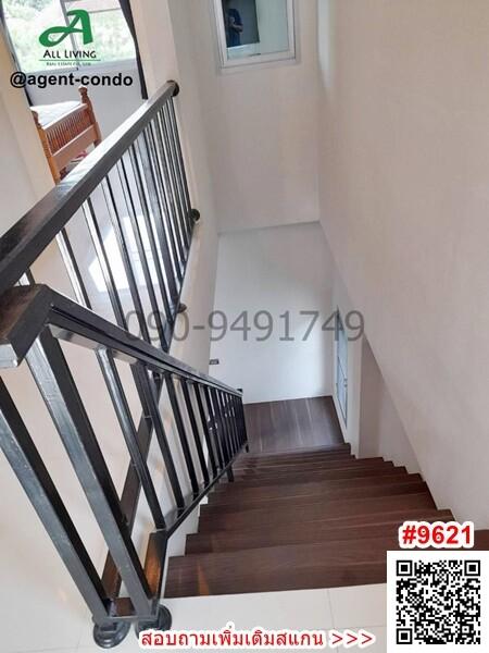 Modern staircase in a residential property with dark wood steps and metal railings