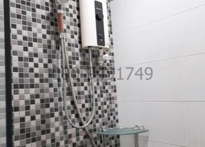 Modern bathroom with wall-mounted shower and black-and-white tiles