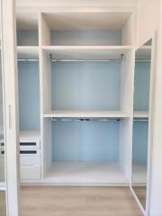Empty bedroom closet with built-in shelves and hanging rods
