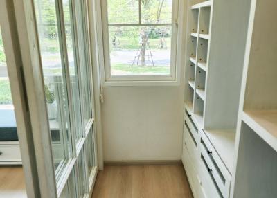 Bright narrow room with large windows and built-in storage