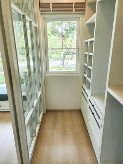 Bright narrow room with large windows and built-in storage