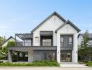 Modern two-story house with a balcony and landscaped front yard