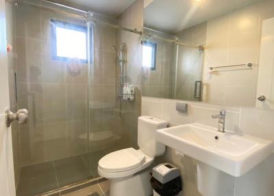Spacious bathroom with walk-in shower, toilet and sink