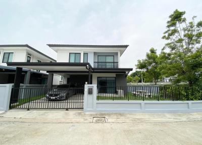 Modern two-story house with balcony and gated carport