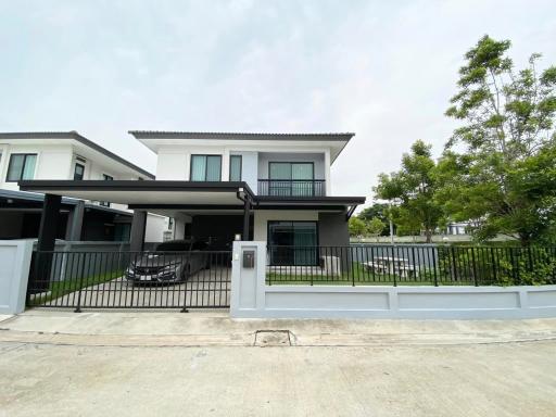 Modern two-story house with balcony and gated carport