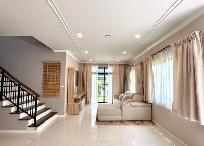 Spacious and well-lit living room with modern staircase