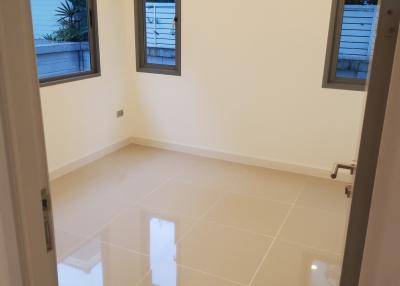 Bright empty bedroom with glossy tiled floor and windows