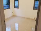 Bright empty bedroom with glossy tiled floor and windows