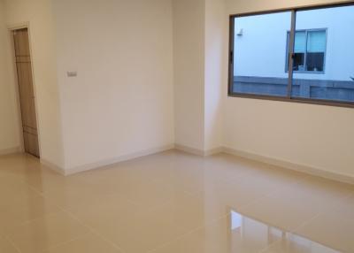 Spacious and well-lit living room with glossy tiled flooring and large window