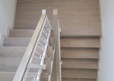 Modern staircase in a new home with wooden steps and white balusters