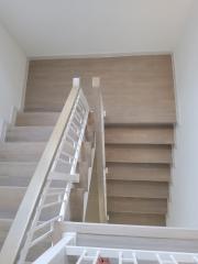 Modern staircase in a new home with wooden steps and white balusters