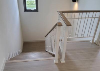 Bright and modern staircase with wooden floor and white balustrade