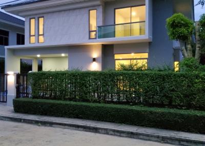 Twilight view of a modern two-story house with balcony and garden