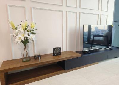 Modern living room with sleek entertainment unit and decorative flowers