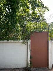 Gate entrance of a residential property surrounded by greenery