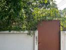 Gate entrance of a residential property surrounded by greenery