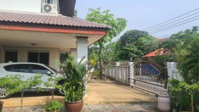 Front view of a residential house with a gated fence and a car parked