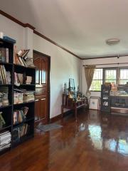 Spacious living room with wooden flooring and bookshelf