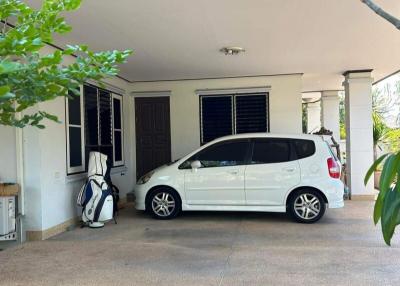 Spacious driveway with parked car and house entrance