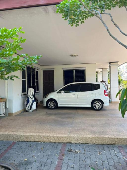 Spacious driveway with parked car and house entrance