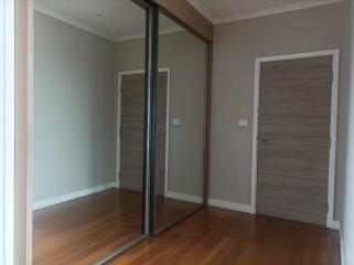 Empty bedroom with wooden floor and mirrored closet doors