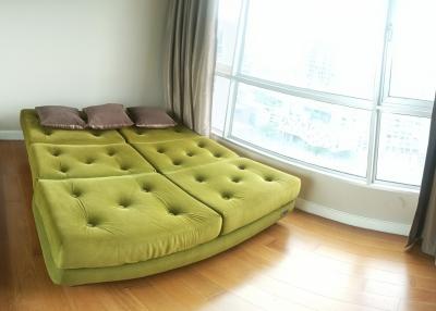 Bright living room with a large window and a unique green sofa