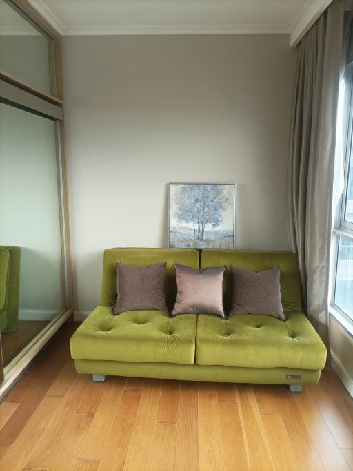 Cozy living room with a green sofa and hardwood floors