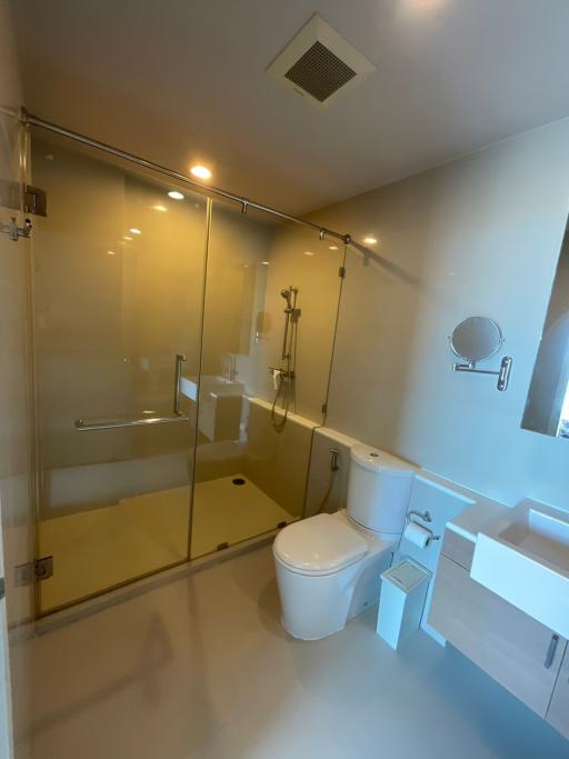 Modern spacious bathroom with glass shower enclosure and sleek fixtures