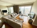 Spacious and well-lit living room with modern furnishings and city view