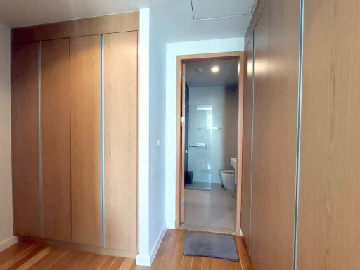 Corridor with wooden flooring leading to a bathroom