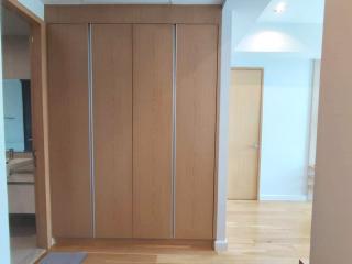 Spacious bedroom with large built-in wardrobe and wooden floor