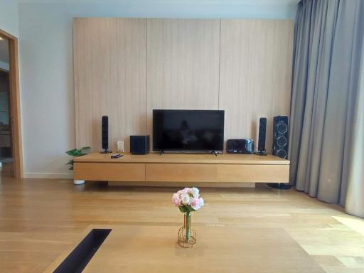 Spacious living room with modern entertainment setup and wooden flooring