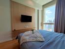 Modern bedroom with king-sized bed, wooden wall paneling, and city view