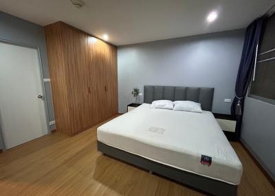 Spacious bedroom with a king-size bed and modern wooden wardrobe