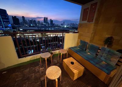 Cozy balcony with comfortable seating and a stunning city view at dusk