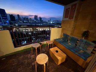 Cozy balcony with comfortable seating and a stunning city view at dusk