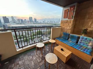 Cozy balcony with seating overlooking a city skyline at dusk