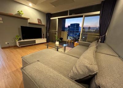 Spacious living room with modern furniture and city view from the balcony