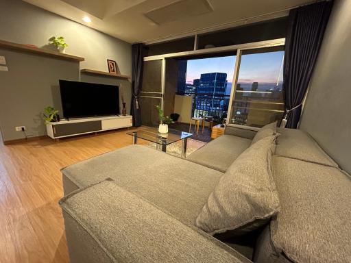 Spacious living room with modern furniture and city view from the balcony