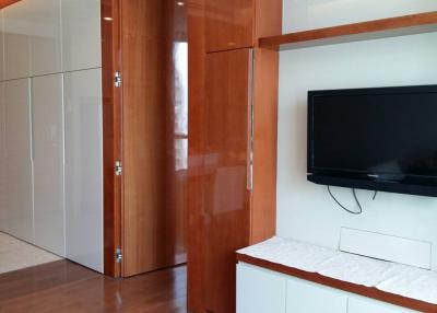 Modern bedroom with wooden cupboard, flat screen TV and wardrobe