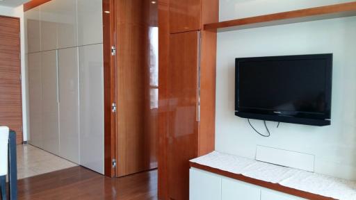 Modern bedroom with wooden cupboard, flat screen TV and wardrobe