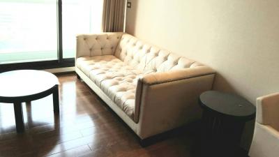 Elegant living room with a large tufted sofa and wooden flooring