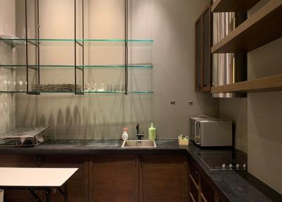 Modern kitchen with dark countertops and elegant glass shelving