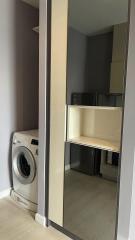 Modern laundry room with washing machine and built-in shelves