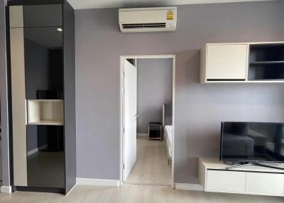 Modern living room interior with electronic appliances and open door leading to another room