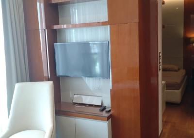 Modern living room with wooden media unit and white chair