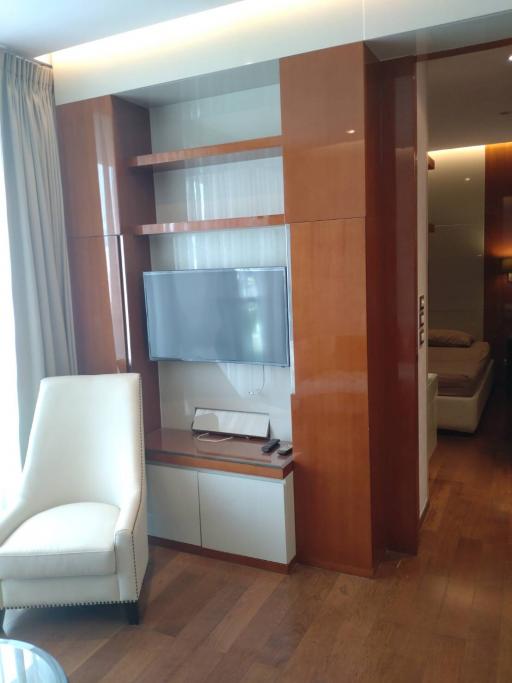 Modern living room with wooden media unit and white chair