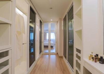 Modern hallway leading to a well-lit bedroom with glass doors