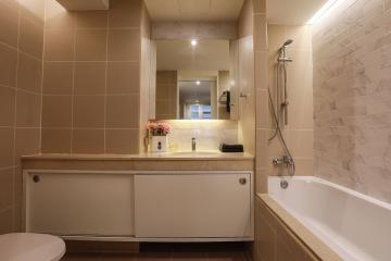 Modern bathroom with warm lighting, a spacious bathtub and built-in vanity