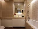 Modern bathroom with warm lighting, a spacious bathtub and built-in vanity